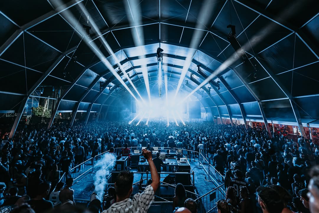 Carpa principal de Aquasella con haces de luz blancos sobre el público
